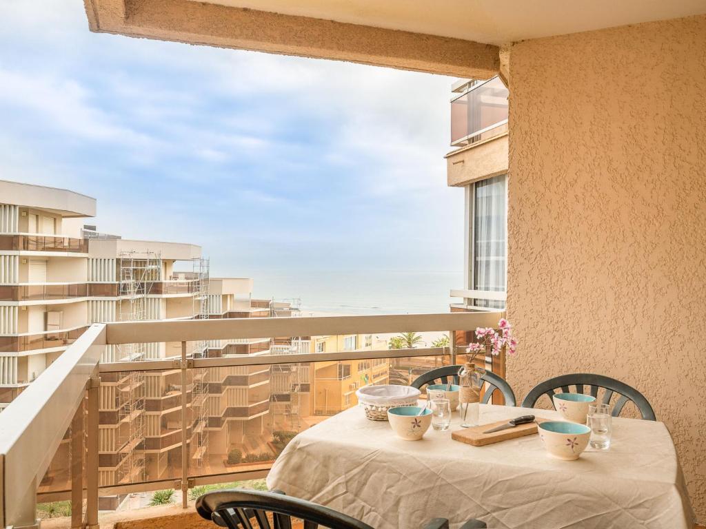 une table sur un balcon avec vue sur une ville dans l'établissement Apartment Les Balcons de la Plage-5 by Interhome, à Canet
