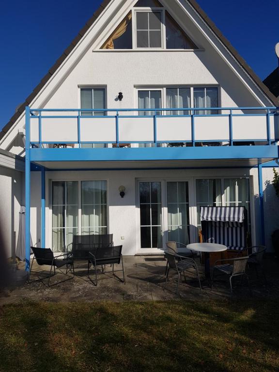 een huis met stoelen en een tafel ervoor bij Strandzauber in Breege