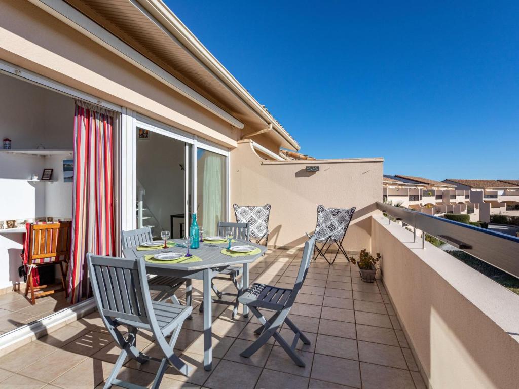 un patio avec une table et des chaises sur un balcon dans l'établissement Apartment Les Reflets-3 by Interhome, à Saint-Cyprien