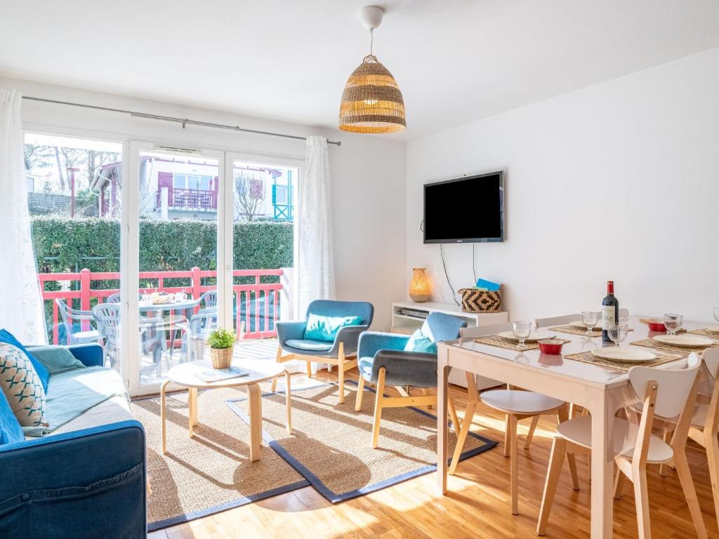 ein Wohnzimmer mit einem Tisch und Stühlen in der Unterkunft Apartment Les Jardins d'Oihana by Interhome in Bidart