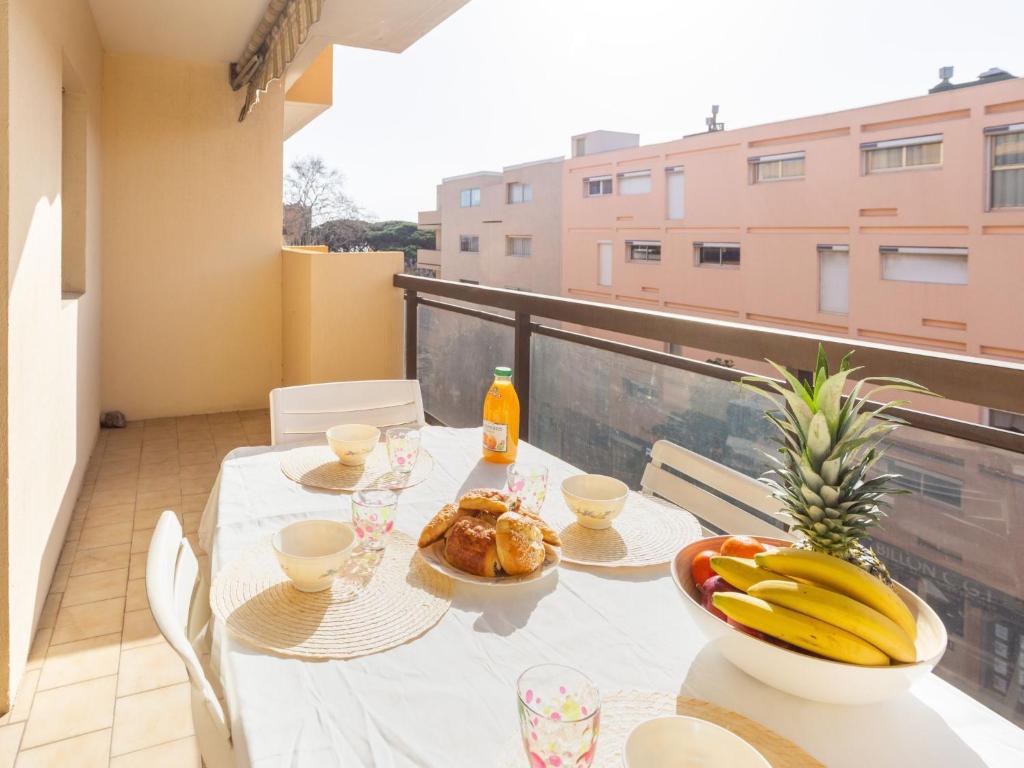 een tafel met eten en bananen op een balkon bij Apartment Saint James-11 by Interhome in Le Lavandou