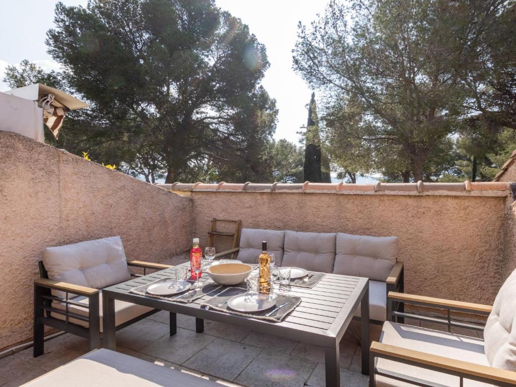 une table et des chaises assises sur une terrasse dans l'établissement Apartment Les Hauts du Port-2 by Interhome, à Saint-Cyr-sur-Mer