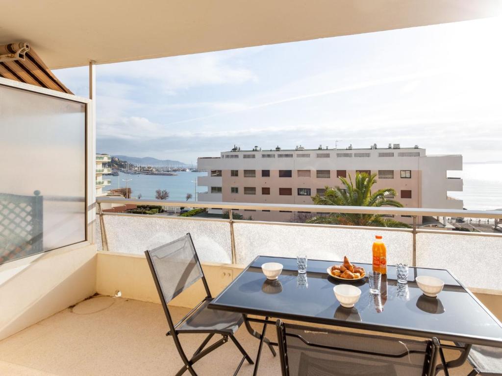 une table et des chaises sur un balcon avec vue sur l'océan dans l'établissement Studio Le Grand Large-2 by Interhome, au Lavandou
