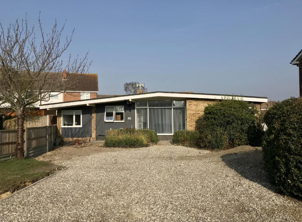 a house with a gravel driveway in front of it at Stanford Villa in Stanford-le-Hope