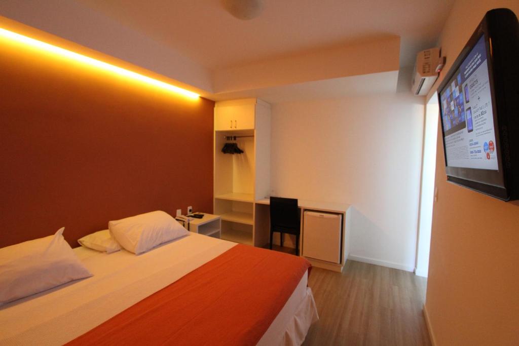 Habitación de hotel con cama y TV de pantalla plana. en Hotel Don Zepe, en Florianópolis