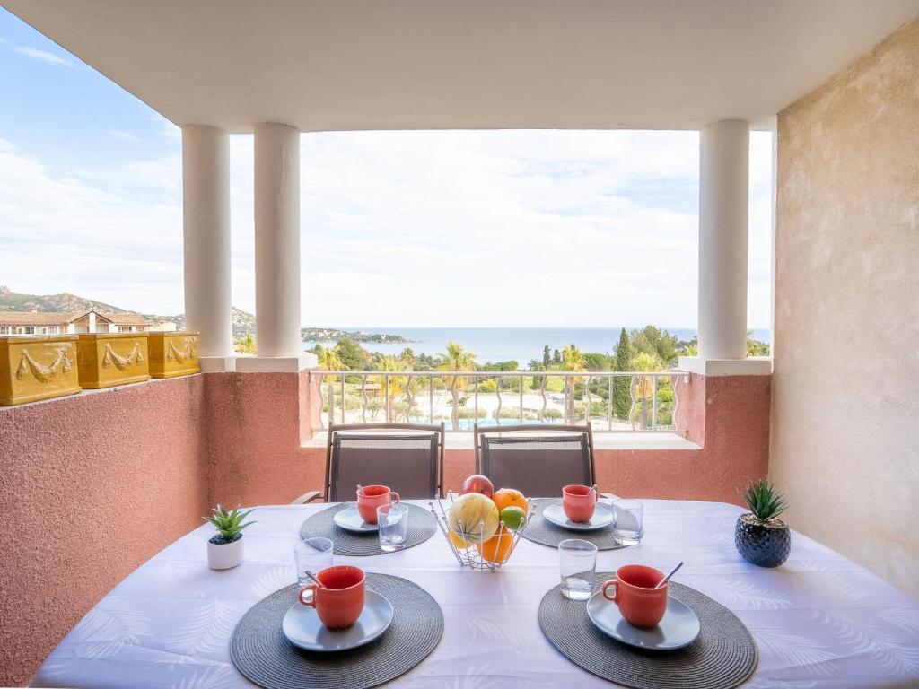 une table avec des assiettes de fruits sur un balcon dans l'établissement Apartment Le Village - E1212 by Interhome, à Agay