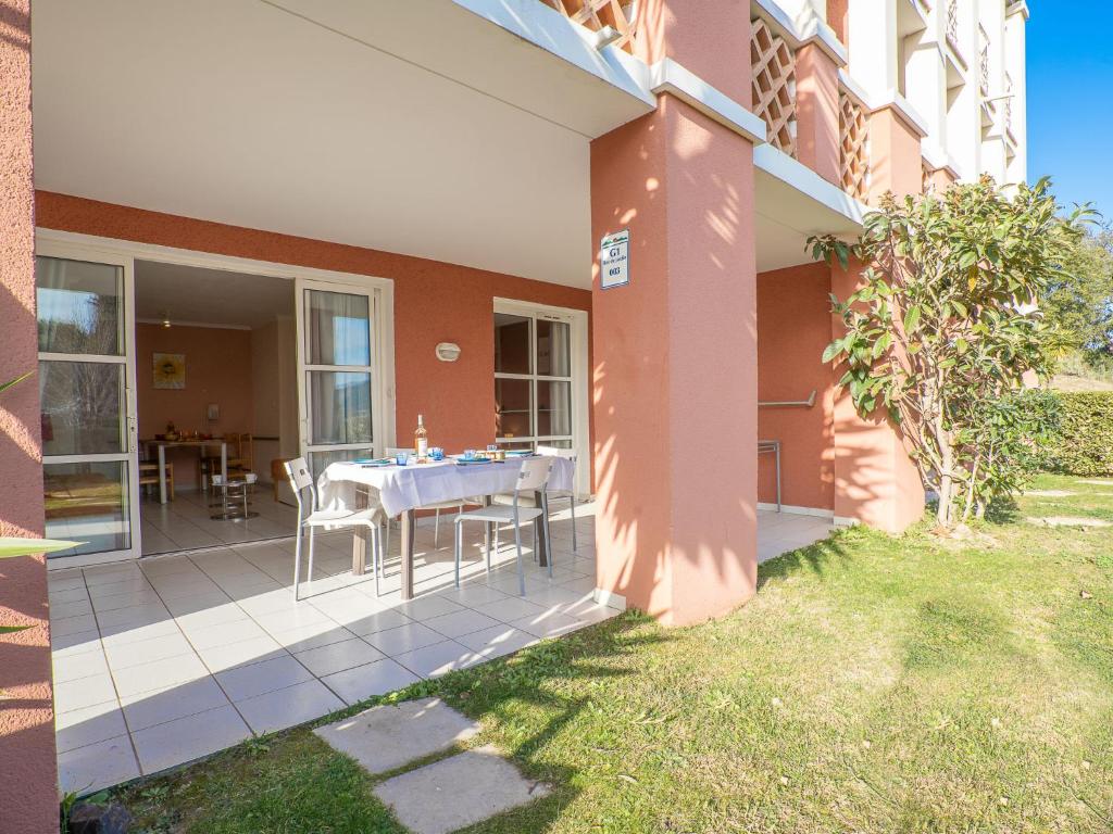 une maison avec une table et des chaises sur une terrasse dans l'établissement Apartment L'Esquinade - G1003 by Interhome, à Agay