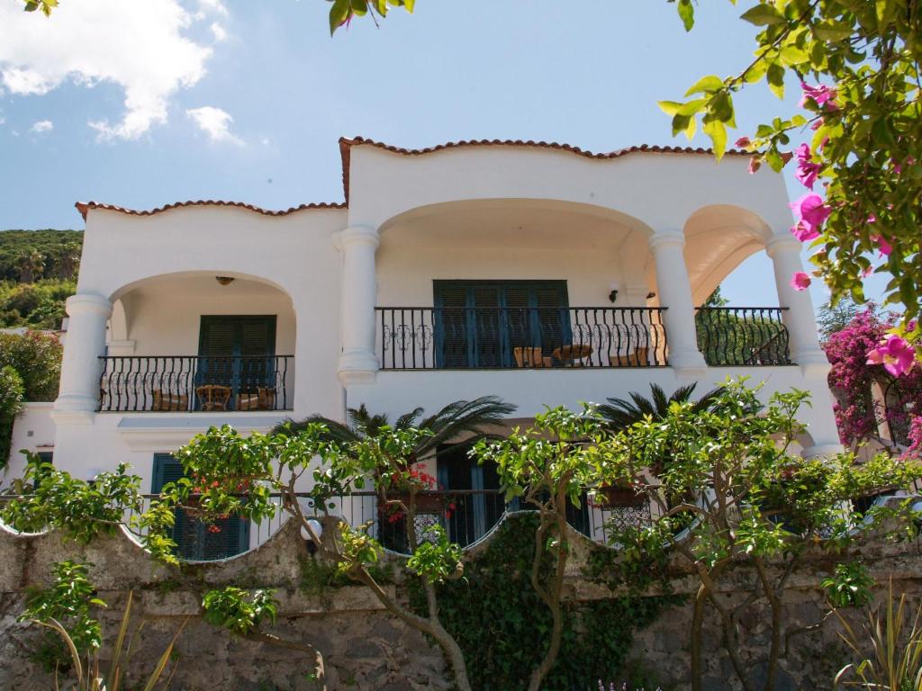 a white house with balconies and trees at Apartment La Penultima-4 by Interhome in Ischia