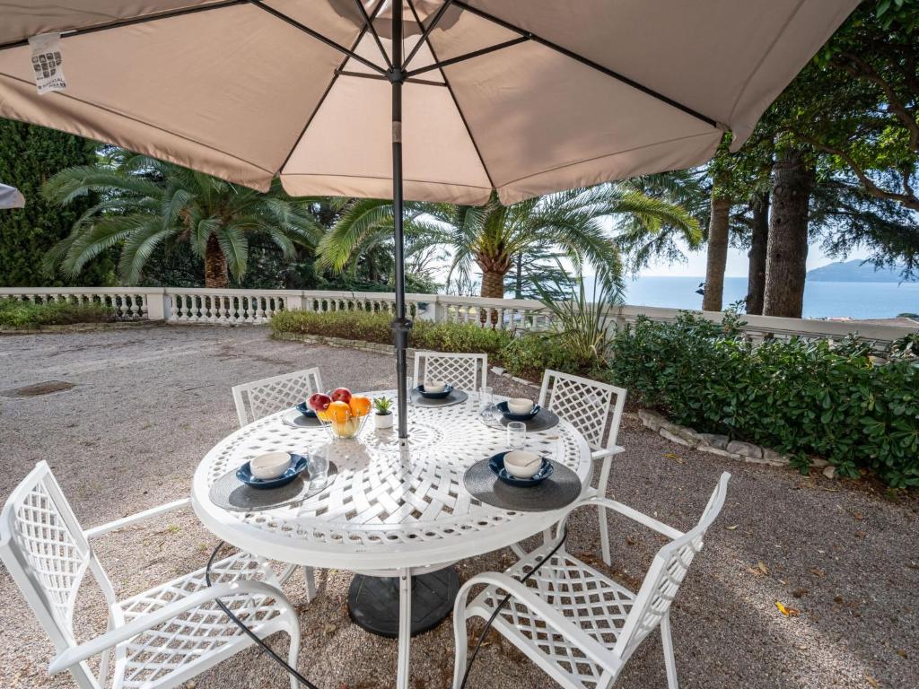 une table et des chaises blanches avec un parasol dans l'établissement Apartment Villa Francia-1 by Interhome, à Cannes