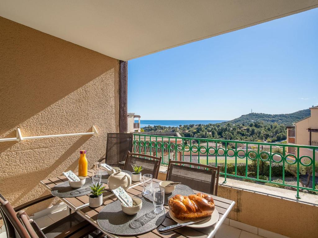- une table avec de la nourriture sur un balcon avec vue dans l'établissement Apartment L'Esquinade - P6 323- place des pêcheurs by Interhome, à Agay