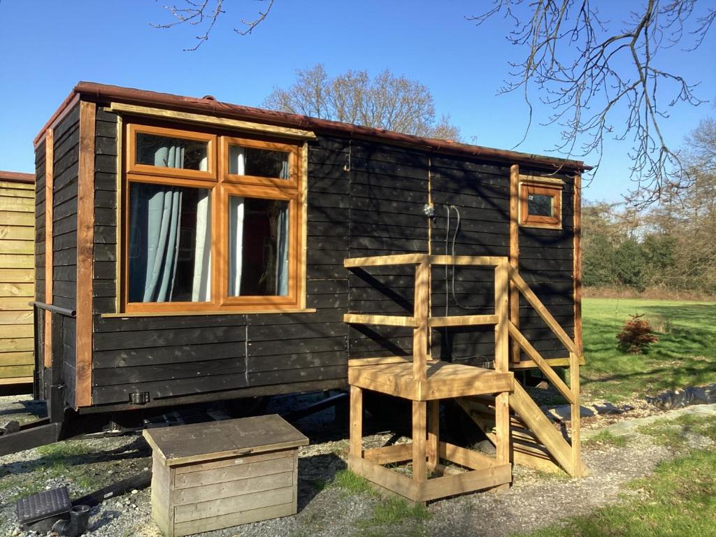 a small cabin with a ladder and a window at Vigo Retreat cabin 1 in Sevenoaks