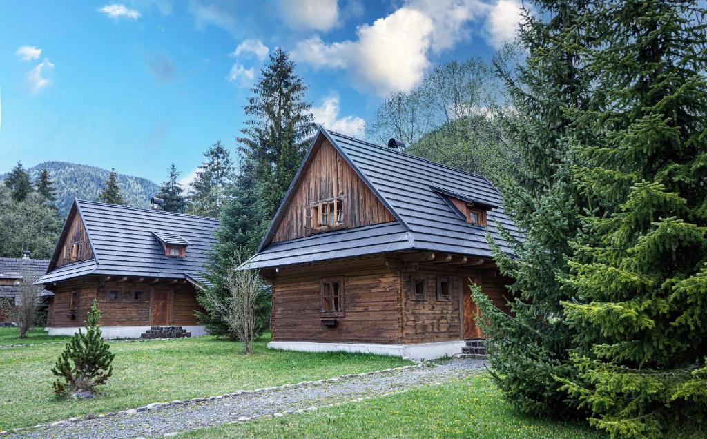 dos casas de madera en un patio con un árbol en Hotel****Liptovský dvor, en Liptovský Ján