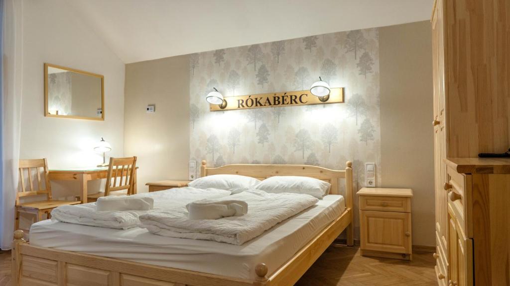 1 dormitorio con 1 cama grande y toallas. en Rókabérc Vadászház Hotel, en Erdőbénye