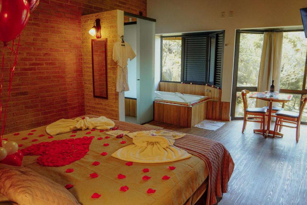 a bedroom with a bed with red roses on it at Terrazzo dos Alpes in Monte Verde