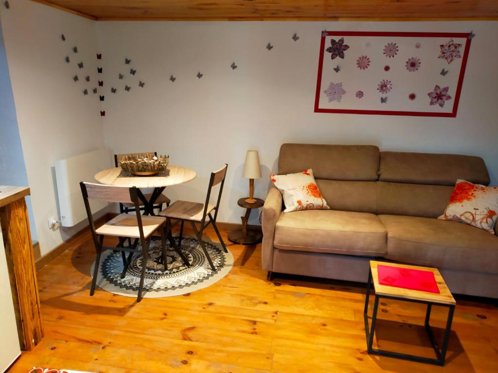 a living room with a couch and a table at L'oustalet de Mamy in Dourbies