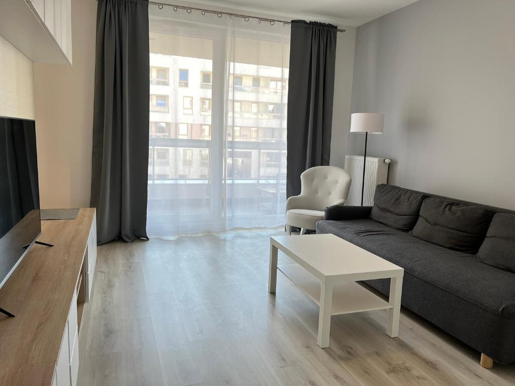 a living room with a couch and a table at Vizja Apartments Kolska 9 in Warsaw