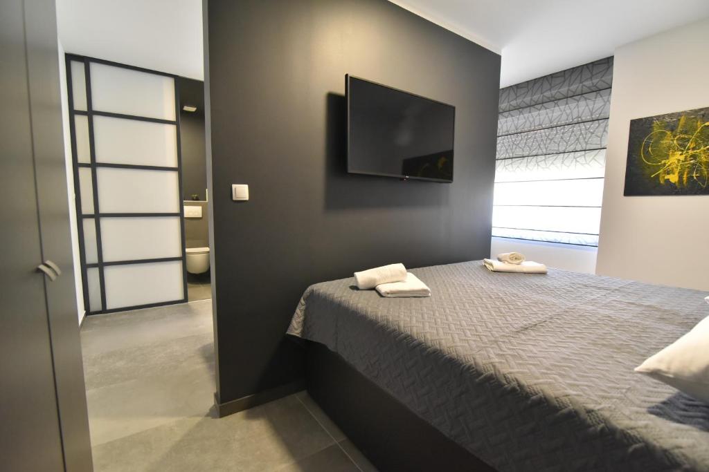 a bedroom with a bed and a flat screen tv at Mido Rooms in Zadar