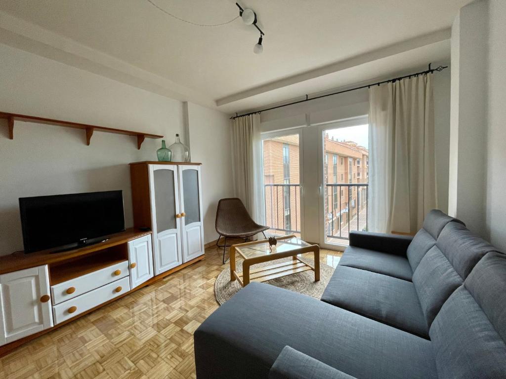 a living room with a blue couch and a tv at KLOLA in Avila