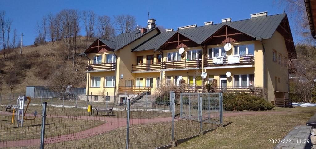 a large building with a tennis court in front of it at Słoneczny Zakątek in Jaworki