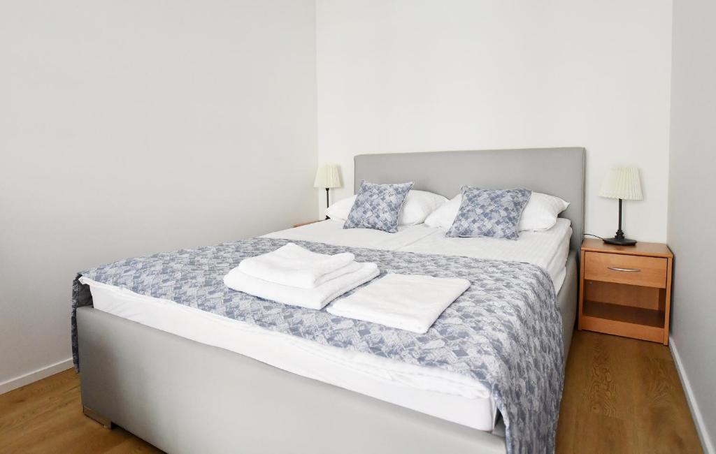 a bedroom with a bed with two towels on it at Apartamenty Navigator-REZYDENCJA SPACEROWA in Kołobrzeg