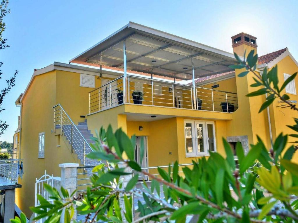 a yellow house with stairs and a balcony at Fancy Apartments Dream in Brna