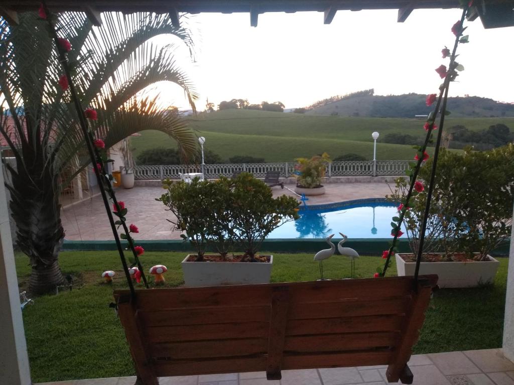 a porch swing with a view of a pool at Chácara reis in Socorro
