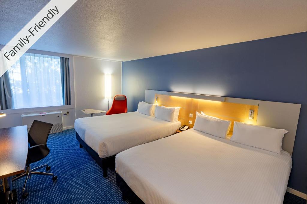 a hotel room with two beds and a desk at Holiday Inn Express Gent, an IHG Hotel in Ghent