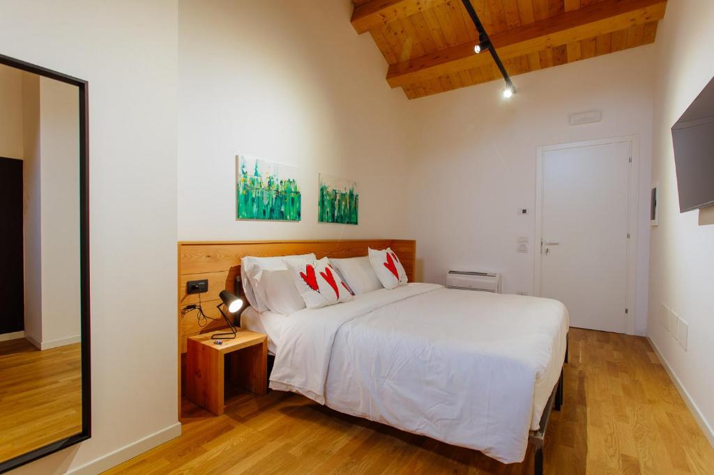 - une chambre avec un grand lit blanc et des oreillers rouges dans l'établissement Dadi Home Camera 5, à Padoue