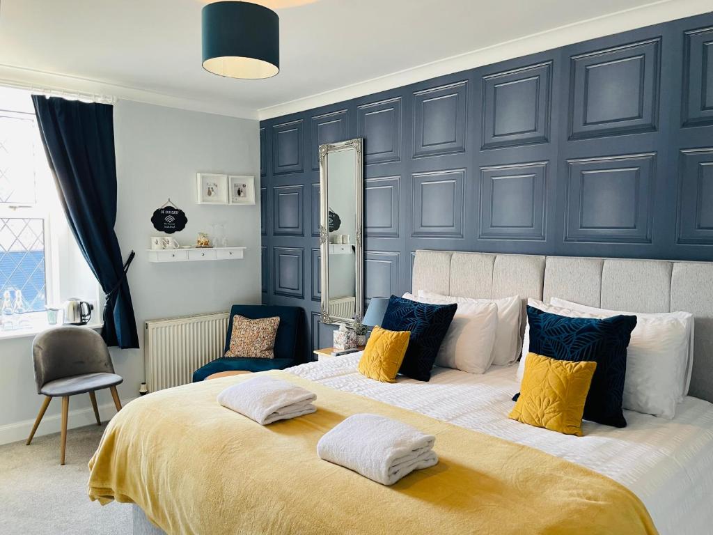 a bedroom with a large bed with yellow and blue pillows at Whinburn Guest House in Fort William