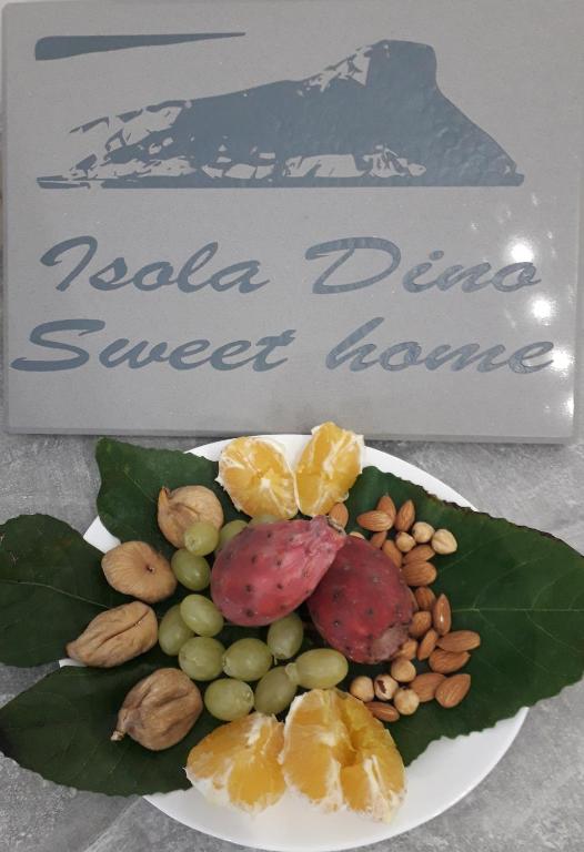 a plate of fruit and nuts next to a sign at IsolaDino b&b sweet home in Praia a Mare