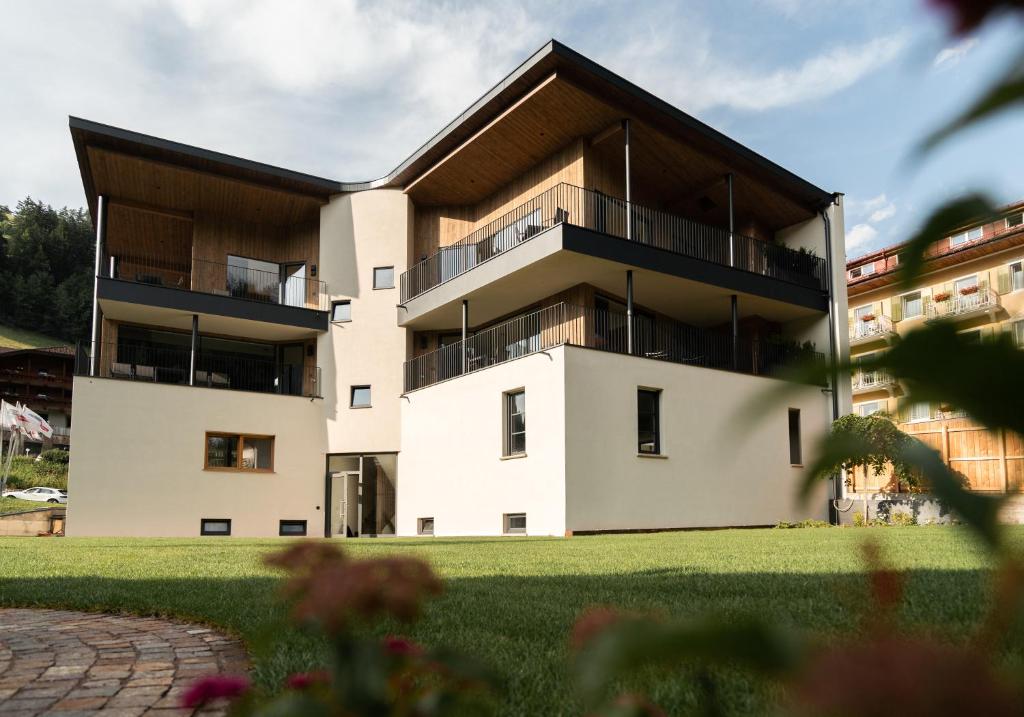 een groot wit gebouw met een zwart dak bij Chalet Insignis in Santa Cristina in Val Gardena