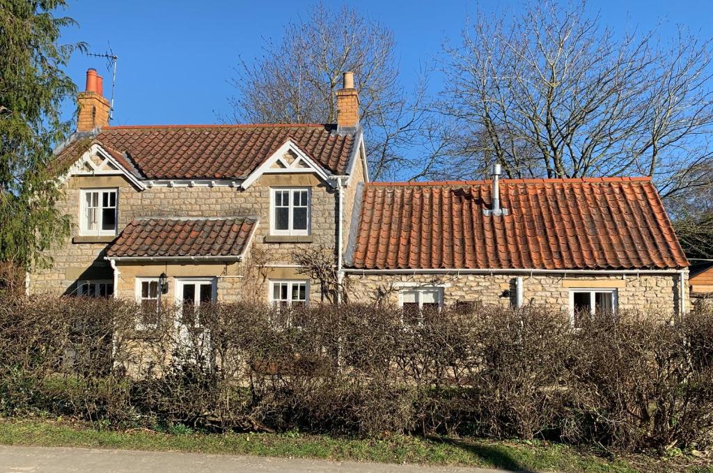 una vieja casa de ladrillo con dos chimeneas. en Forge Cottage, Helmsley, en Helmsley