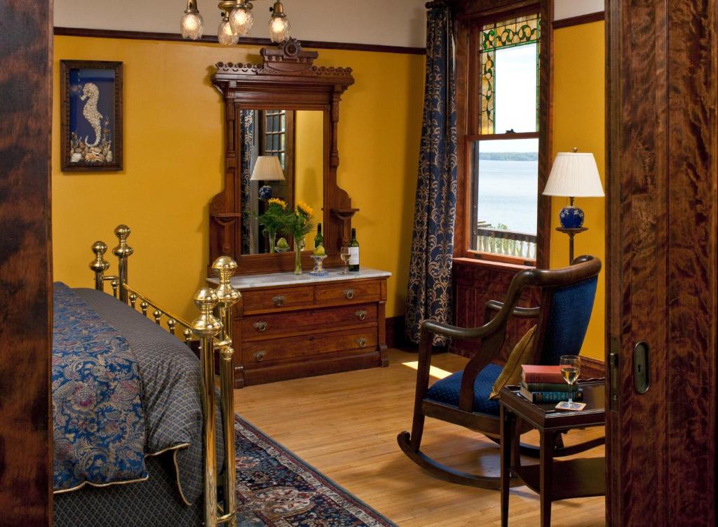 a bedroom with a bed and a dresser and a mirror at Old Rittenhouse Inn in Bayfield
