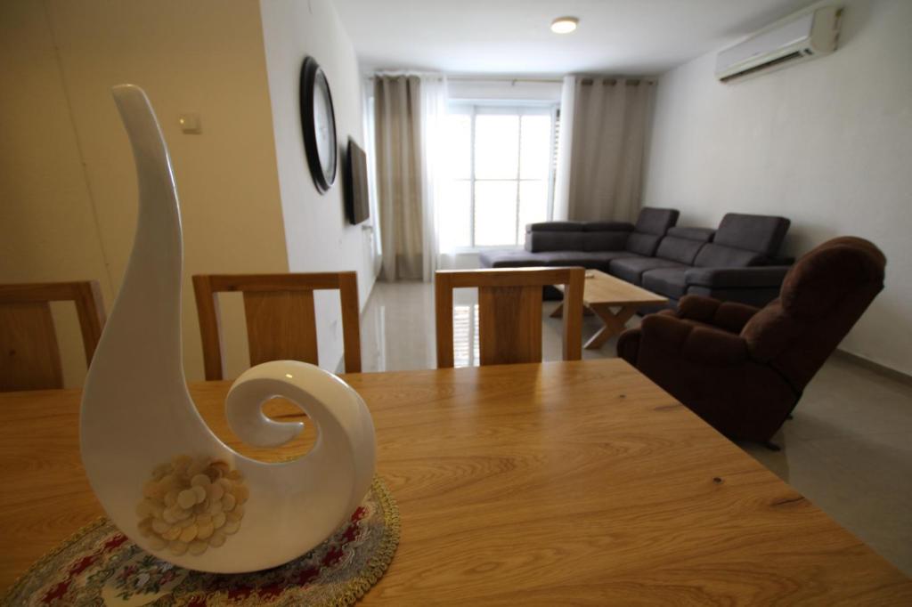 eine weiße Vase auf einem Tisch im Wohnzimmer in der Unterkunft Isramax 3BR apartment near the sea. in Bat Yam