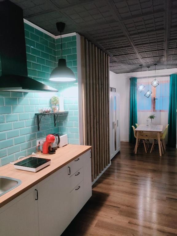 una cocina con azulejos azules y una mesa en una habitación en LoL apartment, en Alicante
