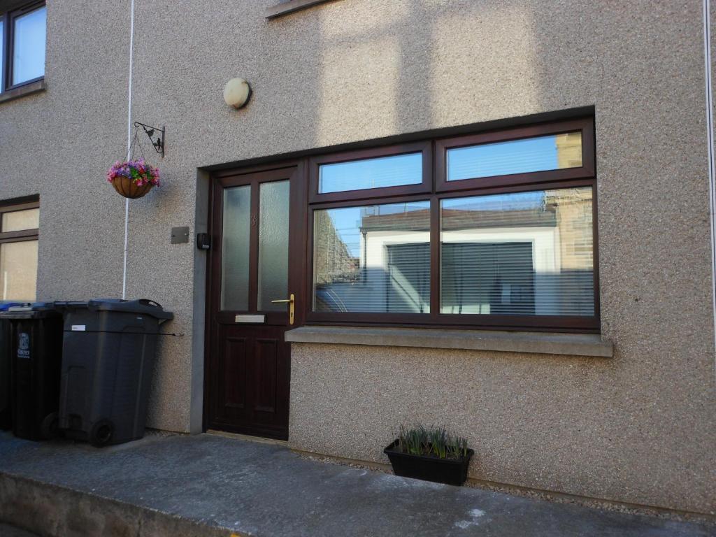 eine Haustür mit Fenster und Mülltonne in der Unterkunft Orkneyinga in Kirkwall