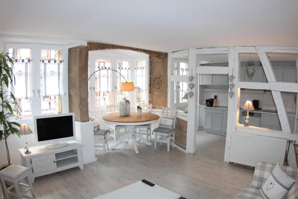 un salon avec une table et une télévision dans l'établissement La Suite du Bouchon - Appartement hyper-centre, à Strasbourg
