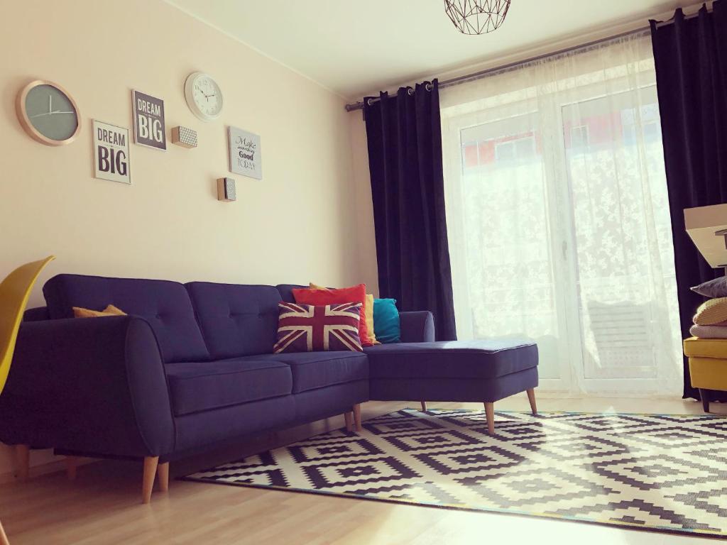a living room with a blue couch and a window at Belle View Apartment Brasov in Braşov
