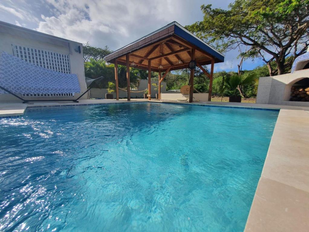 a swimming pool with a gazebo and blue water at The Nest Villa, A Dream Escape for the entire family in Golden Grove