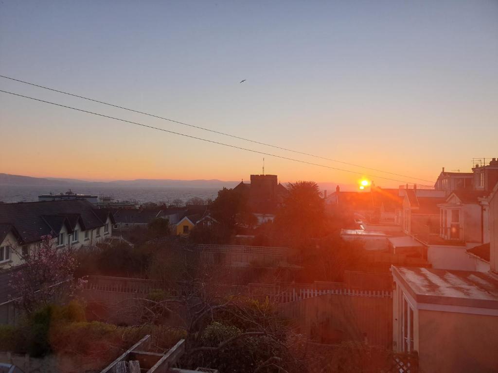 a view of a city at sunset at Quirky spacious with sea views Above an Ale house in The Mumbles