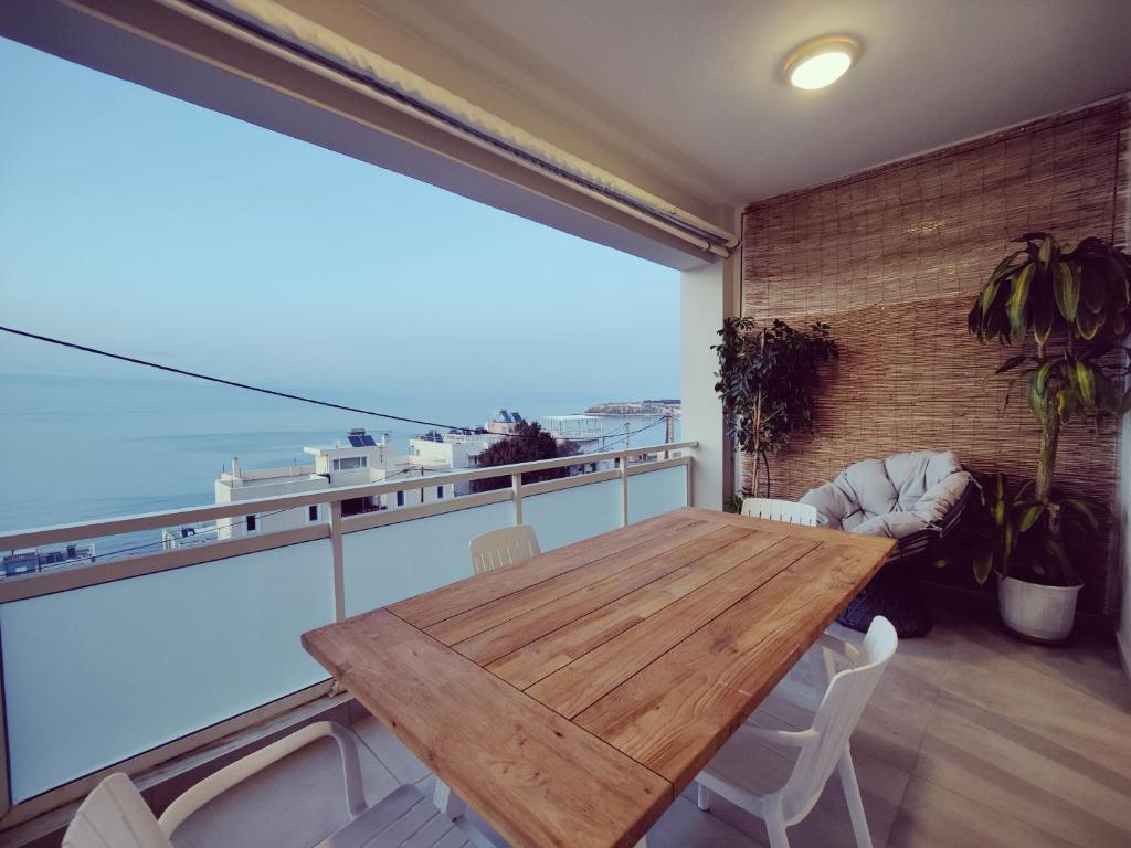 レティムノ・タウンにあるLuxury Seaview Appartmentの海の景色を望むバルコニー(木製テーブル付)