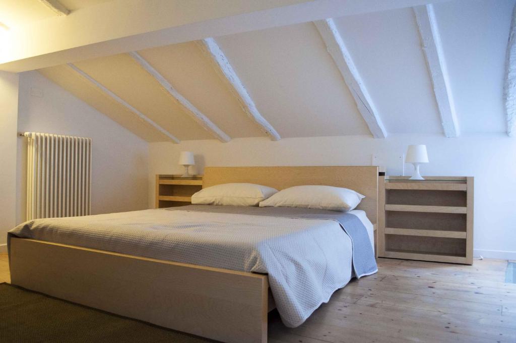 1 dormitorio con 1 cama grande y 2 almohadas en Via de' Falegnami 6 Apartment by Wonderful Italy, en Bolonia