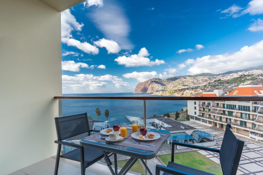 a table and chairs on a balcony with a view of the ocean at Centromar Residence Ocean View By Atlantic Holiday in Funchal