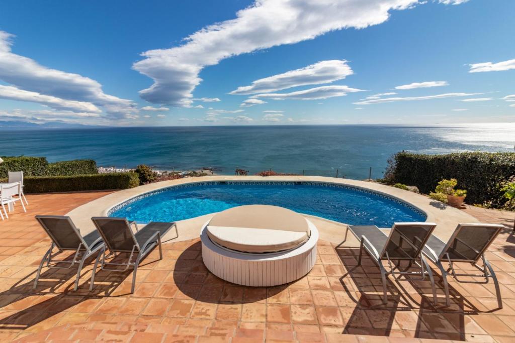 patio con sedie e piscina con vista di Magnífica villa cerca Sotogrande con vista mar excepcional a Manilva