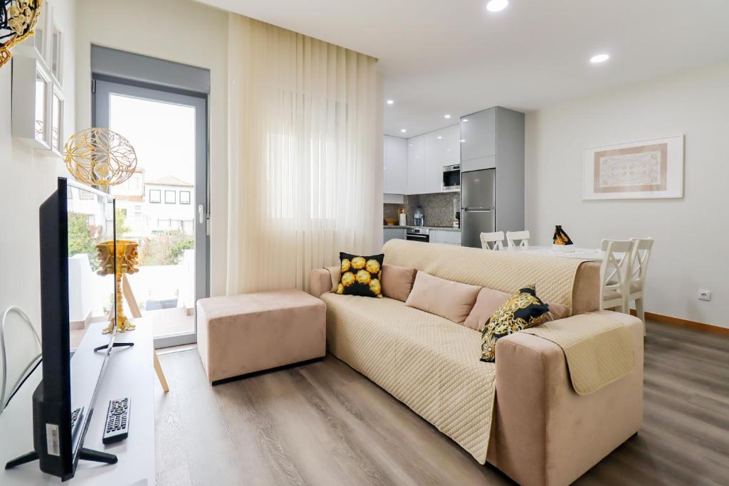 ein Wohnzimmer mit einem Sofa und einer Küche in der Unterkunft Tiana Apartment - City Centre with Terrace in Viana do Castelo