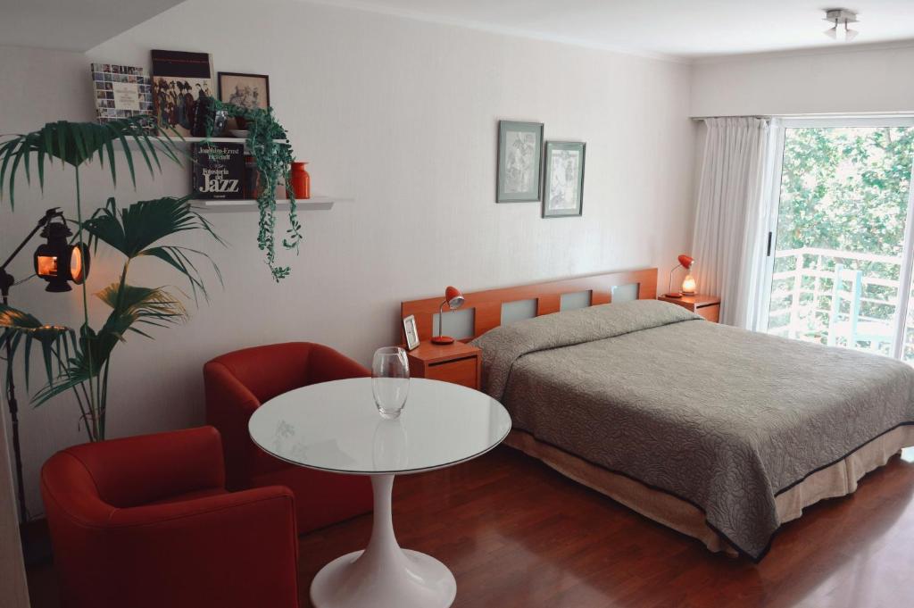 um quarto com uma cama, uma mesa e uma cadeira em Palermo Deluxe Apartment em Buenos Aires