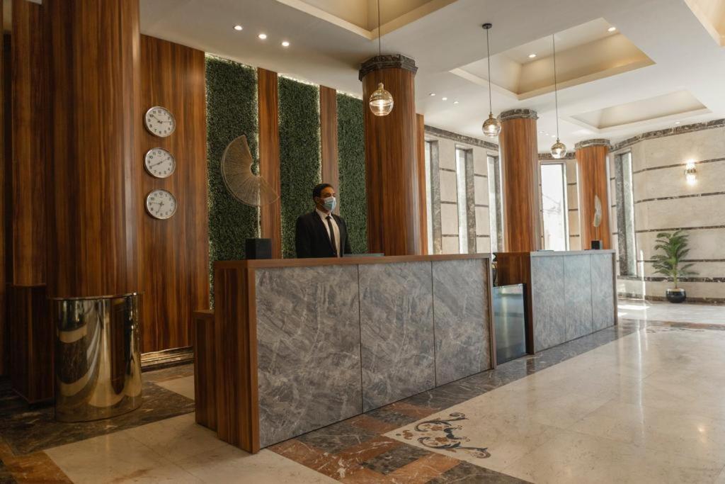 a man standing at a podium in a lobby at Ultra Loaloa Nile Maadi Hotel in Cairo