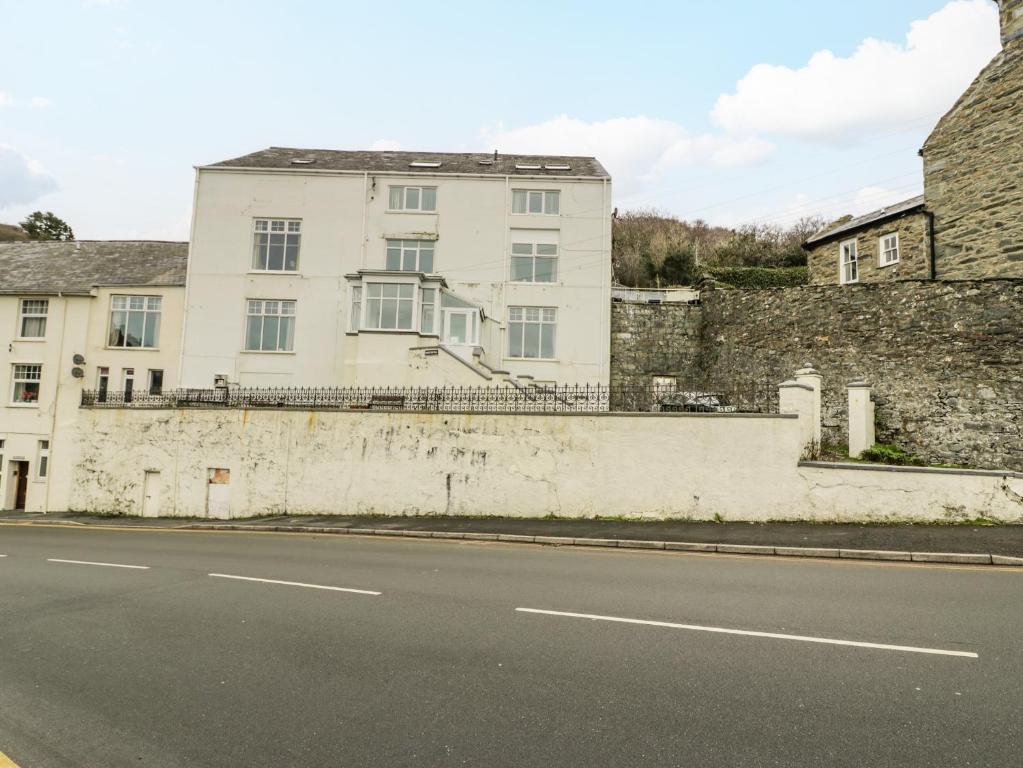 ein weißes Gebäude an der Straßenseite in der Unterkunft Apartment 1 in Barmouth