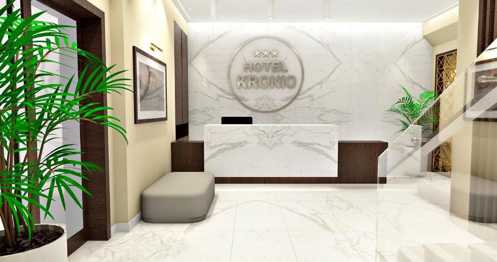 un vestíbulo con una sala de espera con un banco y plantas en Hotel Kronio en Olympia
