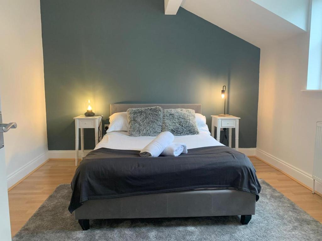 a bedroom with a large bed with two end tables at Biskey Howe Central - FREE off-site Health Club access with Pool, Sauna, Steam Room & Gym in Bowness-on-Windermere